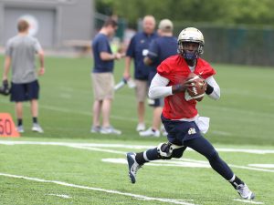 Manny Stocker drops back to pass during the first practice of the season (Photo Credit: David Hague)